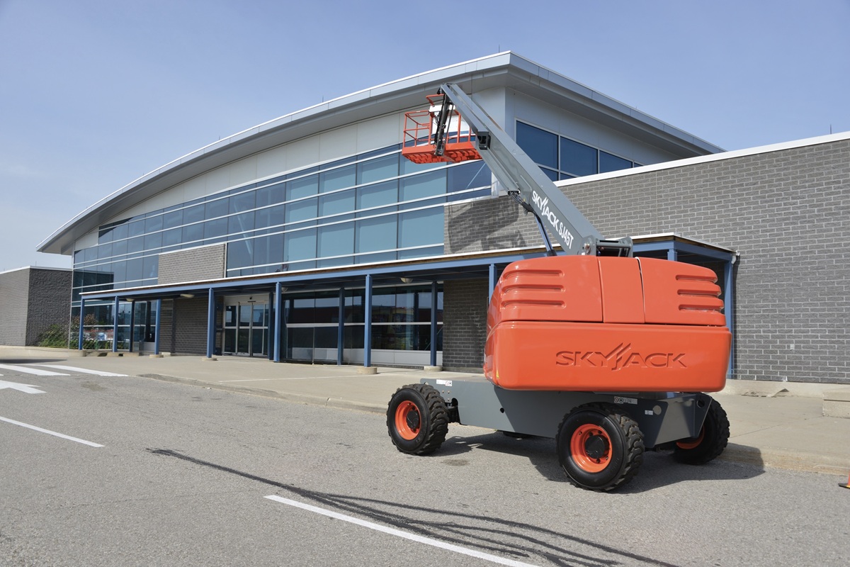 Skyjack SJ45 T telescopic boom lift staged outside a Global Solutions facility